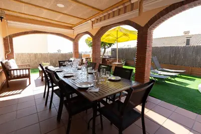 a table and chairs on a patio with an umbrella at Catalunya Casas Cozy beach town villa for 8 - no car necessary! in Pineda de Mar