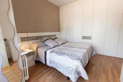 a small bedroom with a bed and a wooden floor at Catalunya Casas Cozy beach town villa for 8 - no car necessary! in Pineda de Mar