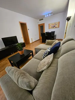 a living room with a couch and a television at Near Ramblas apartment 3 room flat Min 32 days in Barcelona