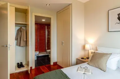 a bedroom with a bed and a bathroom at Canela Homes BARCELONA FÒRUM in Sant Adria de Besos