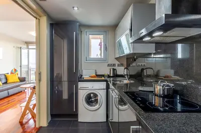 a kitchen with a washer and dryer in it at Canela Homes BARCELONA FÒRUM in Sant Adria de Besos