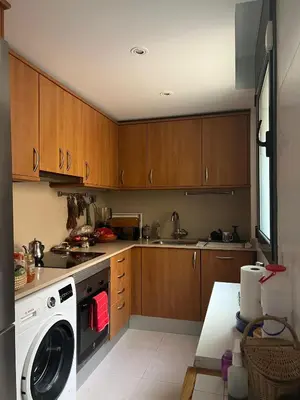 a kitchen with wooden cabinets and a washing machine at Lovely Room near Park Guell in Barcelona