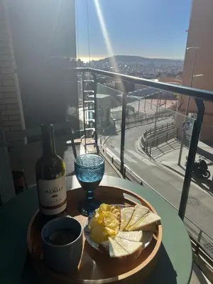 a table with a bottle of wine and a plate of food at Lovely Room near Park Guell in Barcelona