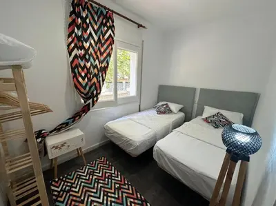 a small bedroom with two beds and a window at Casa Vallromanes Rest House in Vallromanas