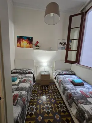 a bedroom with two beds and a lamp in it at Alojamiento Rogeretto in Barcelona