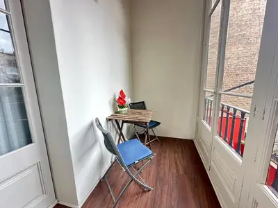 a table and a chair in a room with a window at Alojamiento Rogeretto in Barcelona