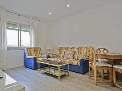 a living room with a blue couch and a table at Winahost Barcelona Diagonal in Barcelona