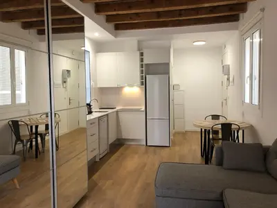 a kitchen and living room with a couch and a table at Charming modern flat in Barcelona in Barcelona