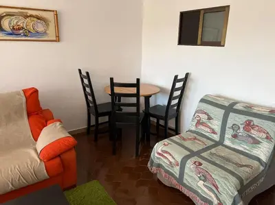 a living room with a couch and a table with chairs at Cozy apartment close to the beach for 2 persons in Gavà