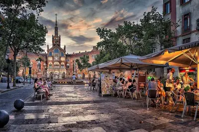 a group of people sitting at tables in front of a building at Acogedor apartamento en la Sagrada Familia in Barcelona