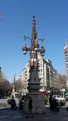 a woman standing in front of a statue in a city at Acogedor apartamento en la Sagrada Familia in Barcelona
