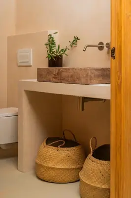 a bathroom with two baskets under a sink at Mas Grimosach - Masía en finca y bodega ecológica - Adults Only in Sant Pau dʼOrdal