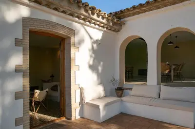 a living room with a white couch on a patio at Mas Grimosach - Masía en finca y bodega ecológica - Adults Only in Sant Pau dʼOrdal