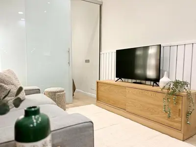 a living room with a flat screen tv on a wooden entertainment center at Eixample Apart Sagrada Familia 52 in Barcelona