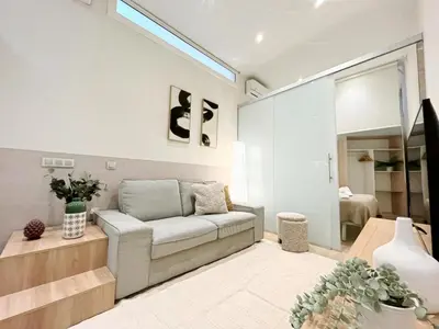 a living room with a couch and a bedroom at Eixample Apart Sagrada Familia 52 in Barcelona