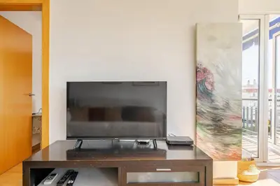 a living room with a large flat screen tv at Apto en la playa a 20 min en tren de Barcelona in Cabrera de Mar