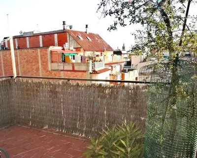 a fence in front of a house with a building at Habitación doble exterior en piso compartido in Sant Cugat del Vallès