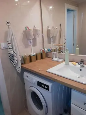 a tv on a white tv stand with a television at Double room with inside window in shared apartment in Barcelona