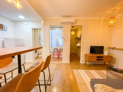 a living room with a table and chairs and a television at Boutique Casanova in Barcelona