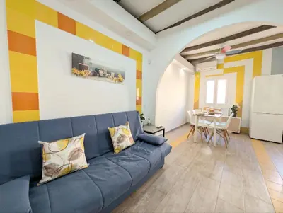a living room with a blue couch and a table at Zona Camp Nou 15 minutos centro en metro in Hospitalet de Llobregat