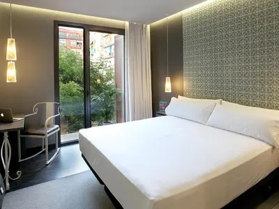 a bedroom with a bed and a desk and a window at Axel TWO Barcelona 4 Sup - Adults Only in Barcelona