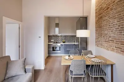 a kitchen and living room with a table and chairs at Pau Claris Double - Home next to Paseo de Gracia in Barcelona