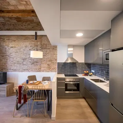 a kitchen with a wooden table and a dining room at Pau Claris - Design apt next to Paseo de Gracia in Barcelona