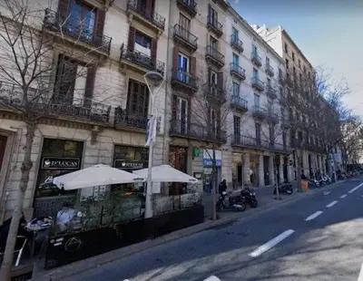 a cafe with umbrellas in front of a building at Pau Claris - Design apt next to Paseo de Gracia in Barcelona