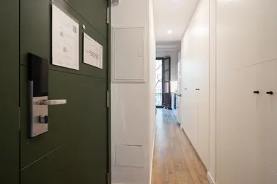 a hallway with white cabinets and a green wall at Ola Living Batlló in Barcelona
