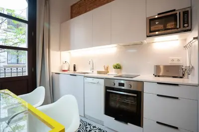 a white kitchen with a sink and a microwave at Ola Living Batlló in Barcelona