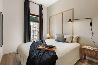 a dining room and living room with a table and chairs at Murtra - 2 bedrooms in Sant Antoni in Barcelona