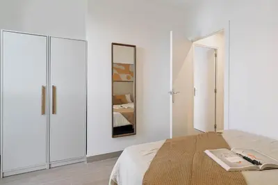 a white bedroom with a bed and a mirror at Sole - 2 bedrooms in Poblenou in Barcelona