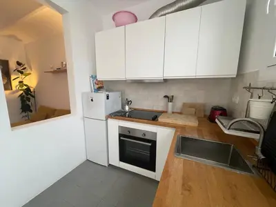 a kitchen with white cabinets and a white refrigerator at Barcelona Besos Apartment | 15' to Plaza Cataluña in Sant Adria de Besos