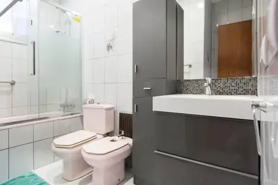 a white bathroom with a toilet and a sink at Modern pad in a great old barrio in Barcelona