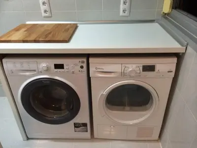 a washer and dryer under a counter in a kitchen at Modern pad in a great old barrio in Barcelona