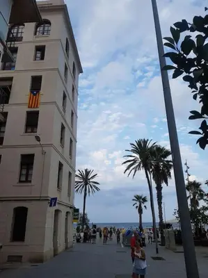 a group of people walking on a sidewalk next to a building at Barceloneta Mar Street - BM11 in Barcelona