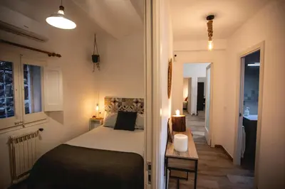 a bedroom with a bed and a table with a lamp at Habitación El Patufet en Casa Camí de les Aigües Monistrol de Montserrat in Monistrol