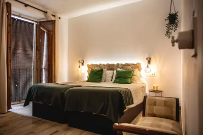 a bedroom with a bed with green pillows and a window at Habitación L'Elefant en Casa Camí de les Aigües Monistrol de Montserrat in Monistrol