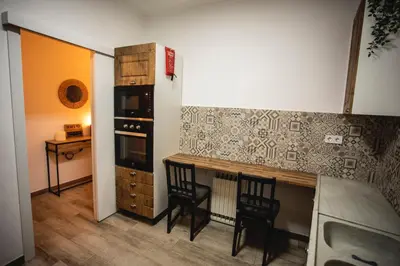a kitchen with wooden cabinets and a stainless steel refrigerator at Habitación L'Elefant en Casa Camí de les Aigües Monistrol de Montserrat in Monistrol
