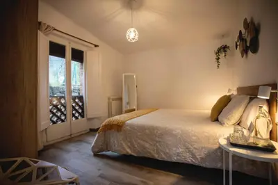 a bedroom with a bed and a table and a window at Habitación Roca Foradada en Casa Camí de les Aigües Monistrol de Montserrat in Monistrol