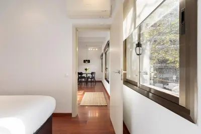 a bedroom with a bed and a hallway with a table at Enjoy Apartments Urban Retreat Valencia 3 in Barcelona