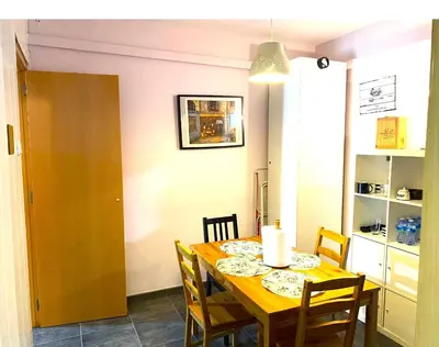a dining room with a wooden table and chairs at L5 Metro Stadium Home in Hospitalet de Llobregat