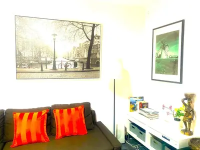 a living room with a couch with red and orange pillows at L5 Metro Stadium Home in Hospitalet de Llobregat