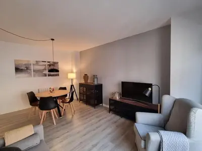 a living room with a couch and a table and a tv at QEhome - confort, parking y cargador EV en el centro de Manresa in Manresa