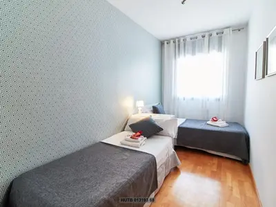 a bedroom with two beds and a window at Alcam Cervantes Playa Badalona in Badalona