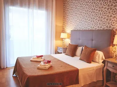 a bedroom with a bed with two towels on it at Alcam Cervantes Playa Badalona in Badalona
