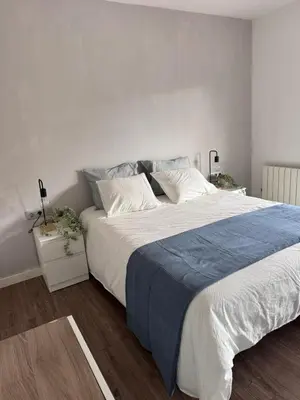 a bedroom with a large bed with a blue blanket at Caldetas relax apartment in Sant Vicenç de Montalt