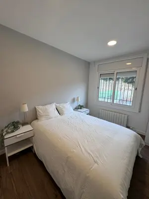 a bedroom with a white bed and a window at Caldetas relax apartment in Sant Vicenç de Montalt