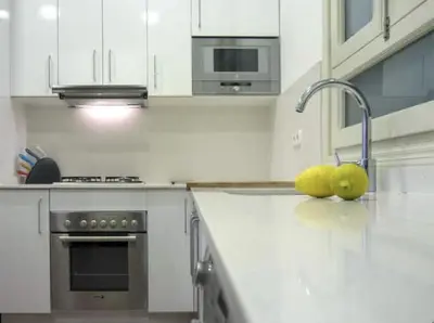 a kitchen with a sink and two apples on the counter at Sitges Seafront BATLLÓ in Sitges