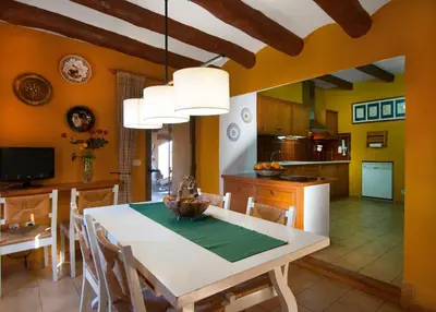 a kitchen and dining room with a table and chairs at Can Julià de Masia Olivera in Subirats